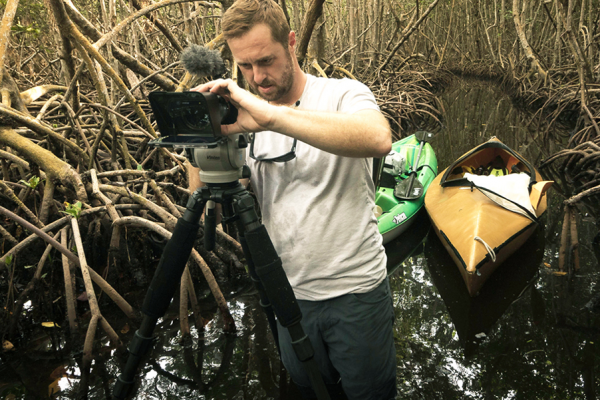 Filmmaker Richard S. Kern films in a tunnel of red mangrove trees in Biscayne Bay